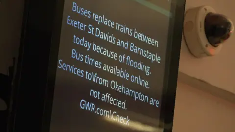 An electronic information sign on the wall of a railway station