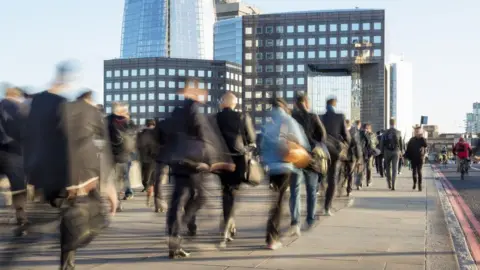 Getty Images A City of London timelapse photo showing a blurred stream of people walking over a bridge