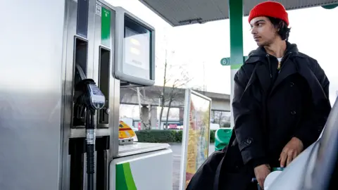 Getty Images Man fills car at petrol pump