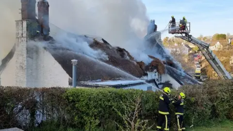 Firefighers tackling thatched roof blaze
