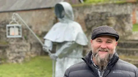 Jamie Niblock/BBC Kevin Baldwin and monk sculpture