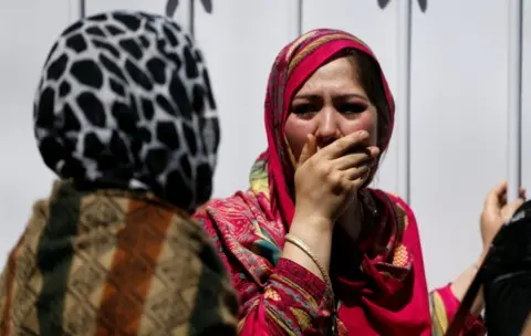 Reuters Bereaved women cover their faces in shock outside a hospital after a truck-bomb attack in Kabul on 31 May 2017