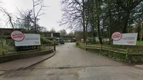 Google A building with circular white signs at the entrace which reads "White Lodge" in Red writing.