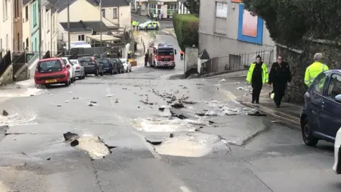 BBC A burst water main in a street