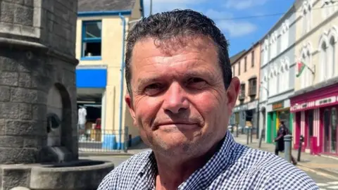 Desmond Edwards sitting on a bench on the Llangefni high street