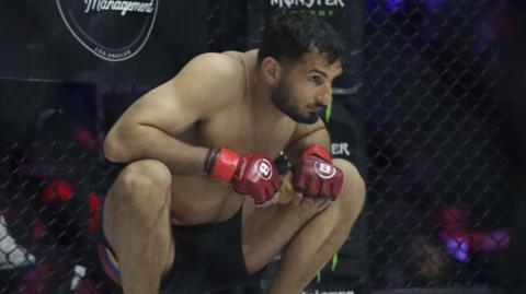 Gegard Mousasi crouches down in the cage