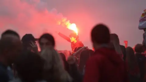 PA Media Liverpool fans let off flares outside the Liver Building in Liverpool.