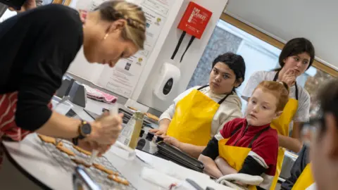 Telford Council Teacher demonstrates how to use an icing piping bag