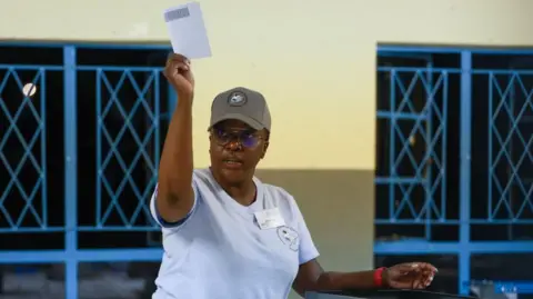 AFP An election official holds up a ballot paper to inspect it.