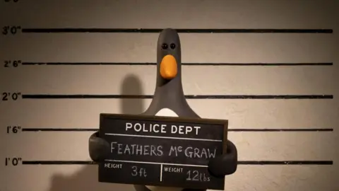 Reuters A plasticine model of a penguin poses for a police mug shot. He holds a board reading Police Dept: Feathers Mc Graw; Height: 3ft; Weight: 12lbs.