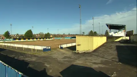 The Camrose has a large grandstand on the right and a smaller standing section on the left of the pitch.