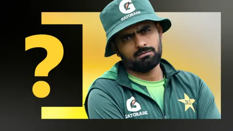 Babar Azam looks on while wearing a green bucket hat and training gear