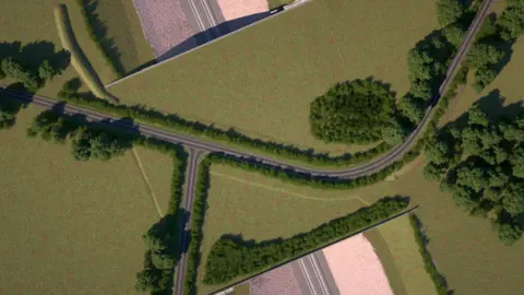 HS2 LTD A computer-generated image shows a bird's eye view of a green bridge carrying a road and covered in tress and grass over the top of a train line 