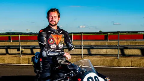 Chris Ganley/Kingsize Photography Motocyclist Chris Ganley sitting on his old race bike