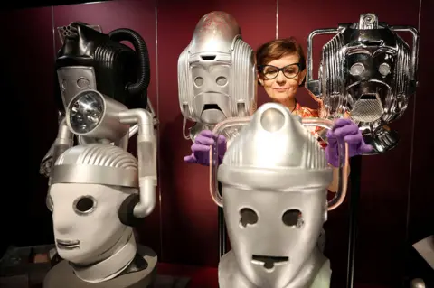 Phil Noble / Reuters A sculpture conservator adjusts a display of cybermen heads at the Doctor Who Worlds of Wonder exhibition at the World Museum in Liverpool, UK