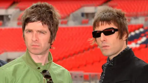 Liam and Noel Gallagher looking right at the camera at a press call at Wembley Stadium in 2009