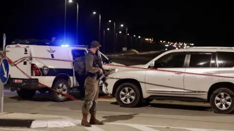 Getty Images Israeli police by the Israeli man's car attacked near Jericho on Monday