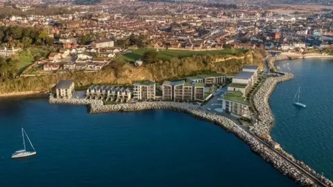 A computer generated image of a large development on the edge of a cliff face. In front of the cliffs are CGI rows of flats and houses, with green flat roofs. Weymouth can be seen sprawling on the land behind. 