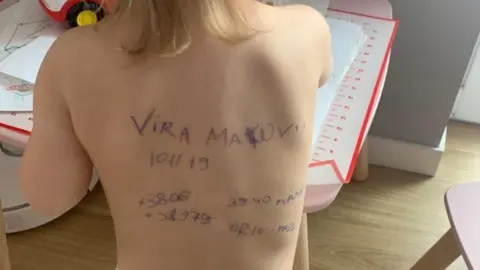 Sasha Makoviy Image shows writing on toddler's back