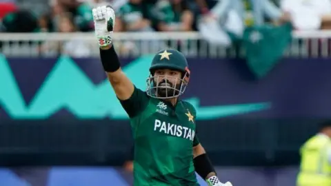 Pakistan batter Muhammad Rizwan gestures by raising his glove