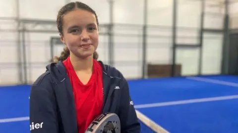 BBC Chloe de la mare at the Guernsey padel club holding a racket