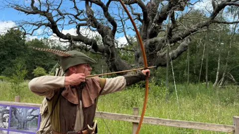 Robin Hood in front of tree
