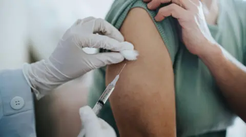 Close up of senior woman getting Covid-19 vaccine in arm for Coronavirus immunization by a doctor at hospital. Stock photo