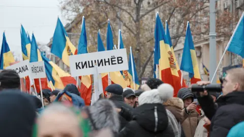 Max Lomakin Moldovans protesting against the President hold up flags and signs