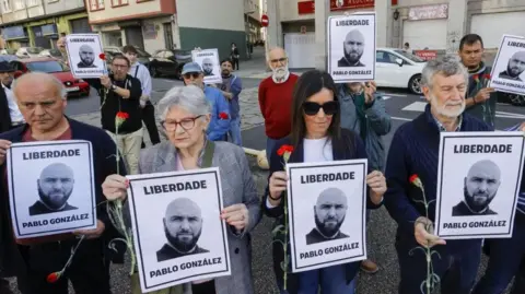 Reuters People carry portraits of Pablo Gonzalez during a rally asking for his release in Ferrol, Galicia, north-western Spain, 8 April 2023