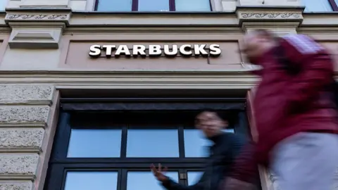 Reuters people walk past Starbucks in Moscow