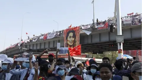 EPA Demonstrators hold placards and shout slogans during a protest against the military coup at the Hledan junction in Yangon, Myanmar, 10 February 2021.