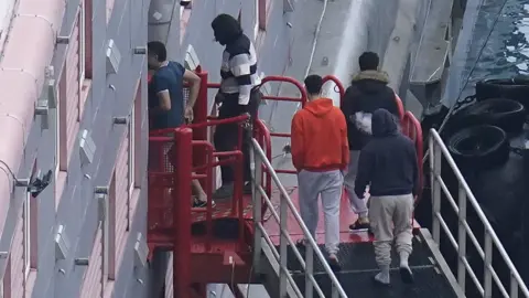PA Media Migrants boarding the barge