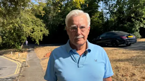 Chairman of the Federation of Oxshott Residents and Associations, Ian Dilks, looks straight at the camera.
