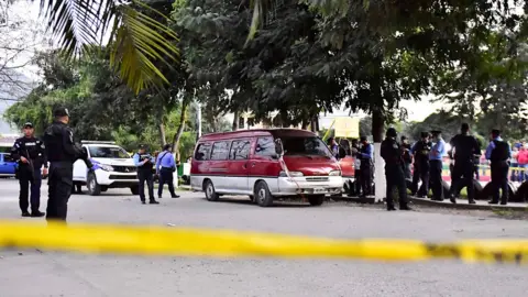 EPA Members of the Honduran Police stand guard next to a vehicle allegedly used in a shooting