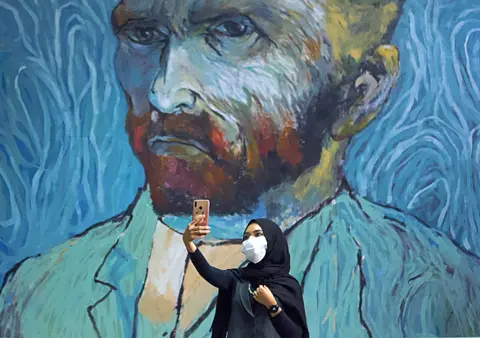 Ajeng Dinar Ulfiana / Reuters A woman takes a selfie with a large mural of Van Gogh