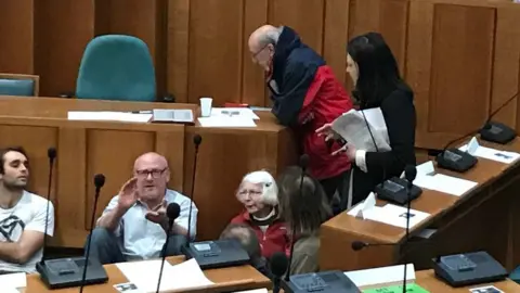 Independent councillor Alexandra Kemp tried to convince protestors to leave the chamber.