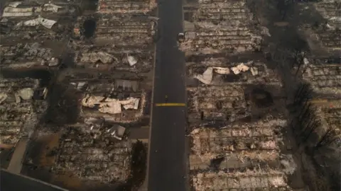 Reuters A person walks past gutted homes in the Medford Estates neighborhood in the aftermath of the Almeda fire