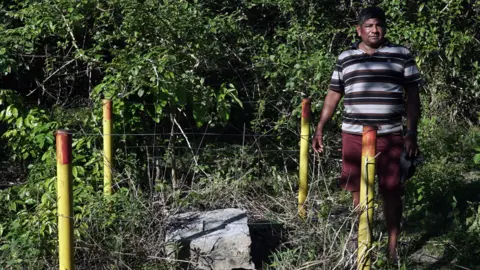 Thaïs Borges Aldinélson Pavão standing next to the exploratory well