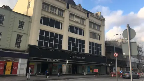 Debenhams on Stockton High Street on its final day of trading. The four-storey white stone building has a black sign on the front which reads: "Debenhams".