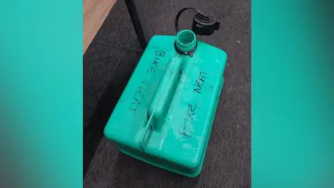 North West Leicestershire District Council A green petrol can marked with the words 'bike neat' in pen placed on a carpet