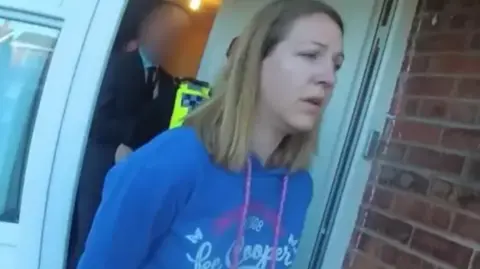 Cheshire Constabulary Lucy Letby, pictured in a blue top, during her arrest at her home in 2018.