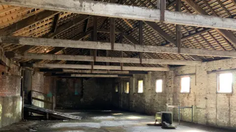 Newcastle City Council The inside of the Coppersmith Shop. It has a high, vaulted ceiling. The room is empty and light shines through empty windows.