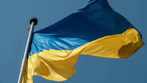 Ukraine flag with blue and yellow horizontal colours flying in the wind 