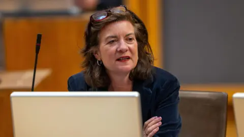 Senedd Cymru Eluned Morgan sat in the Senedd debating chamber