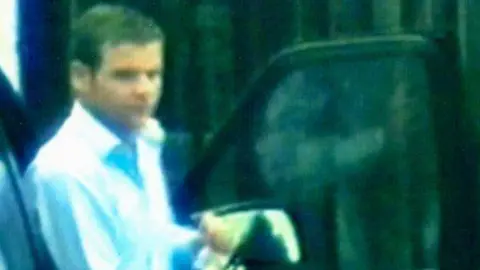 HMRC A screengrab of HMRC's covert filming of Rory Trainor for a previous money laundering investigation which ended in 2014.  Trainor was filmed getting of a black vehicle.  He had short hair and was wearing a pale-coloured open-neck shirt. 