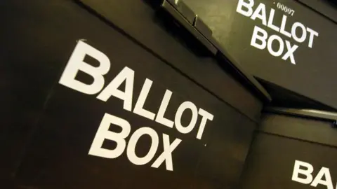 BBC Three black plastic ballot boxes sat on top of each other.