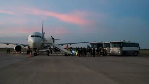 Getty Images: Migrants board a deportation flight to Venezuela in October 2023