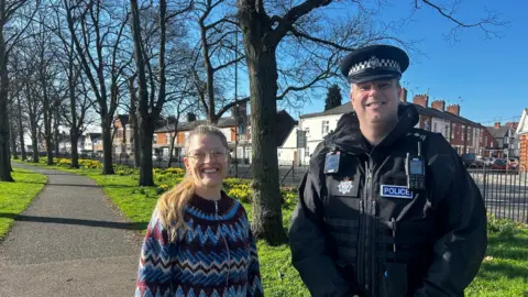 Elly Cutkelvin and Paul Crewe stood in the sunshine on a park just off a road in Saffron Lane