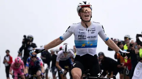 Demi Vollering celebrates as she crosses the finish line to win stage eight of the Giro d'Italia Women 2026