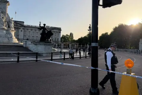 Police guard a cordon outside the Queen Victoria Memorial by Buckingham Palace.